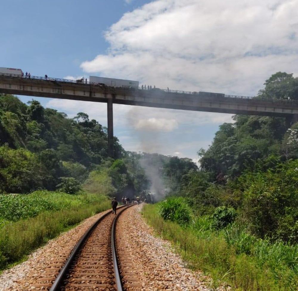 Do alto do viaduto pessoas olham para o ônibus que caiu de um altura de 15 metros perto de uma linha férrea. — Foto: Redes sociais
